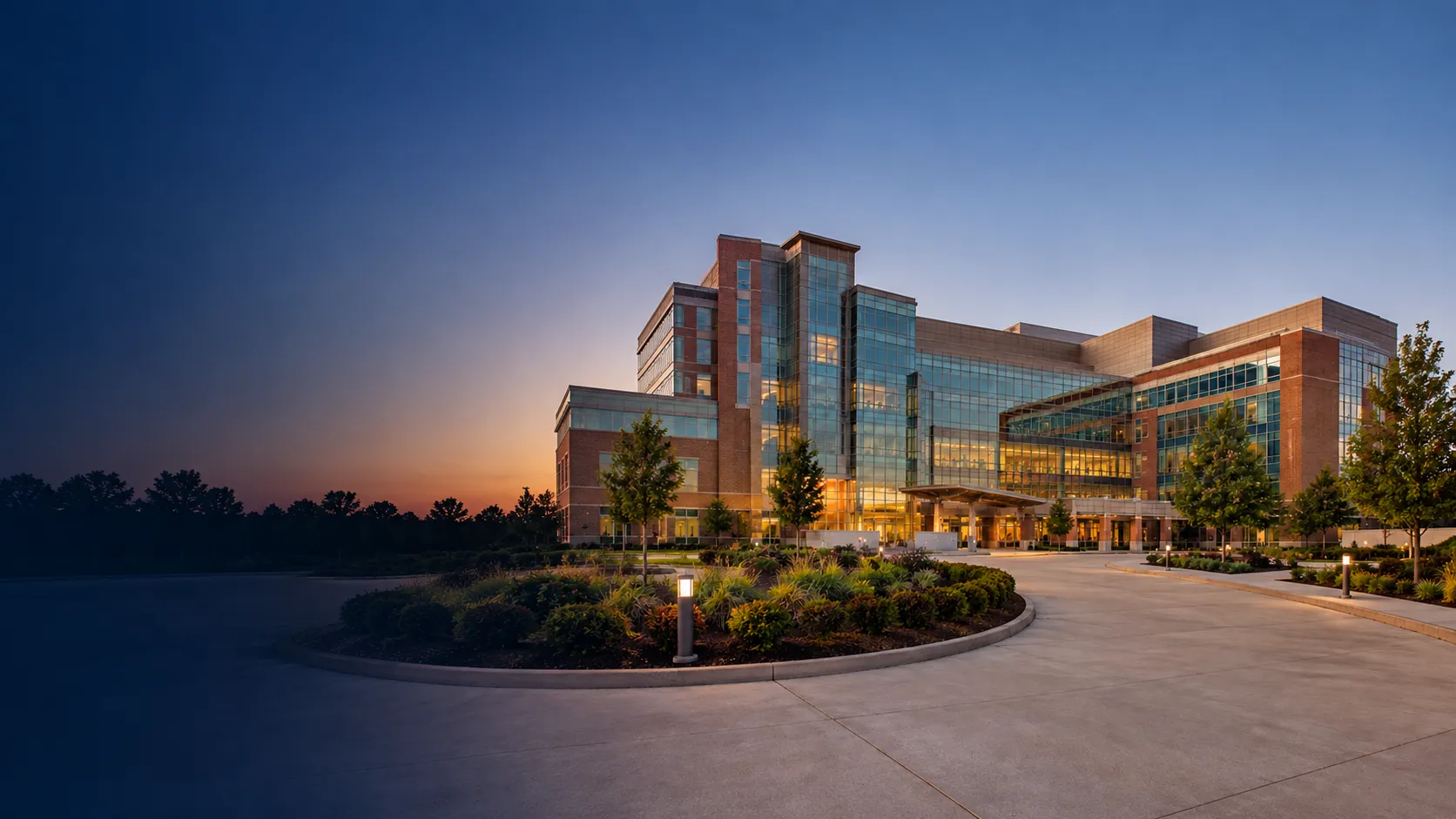 A modern academic healthcare campus at dusk.