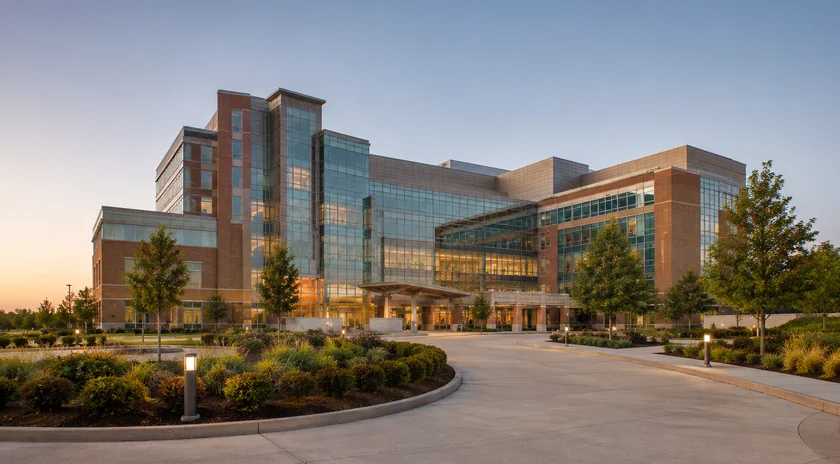 A modern academic healthcare campus at dusk.