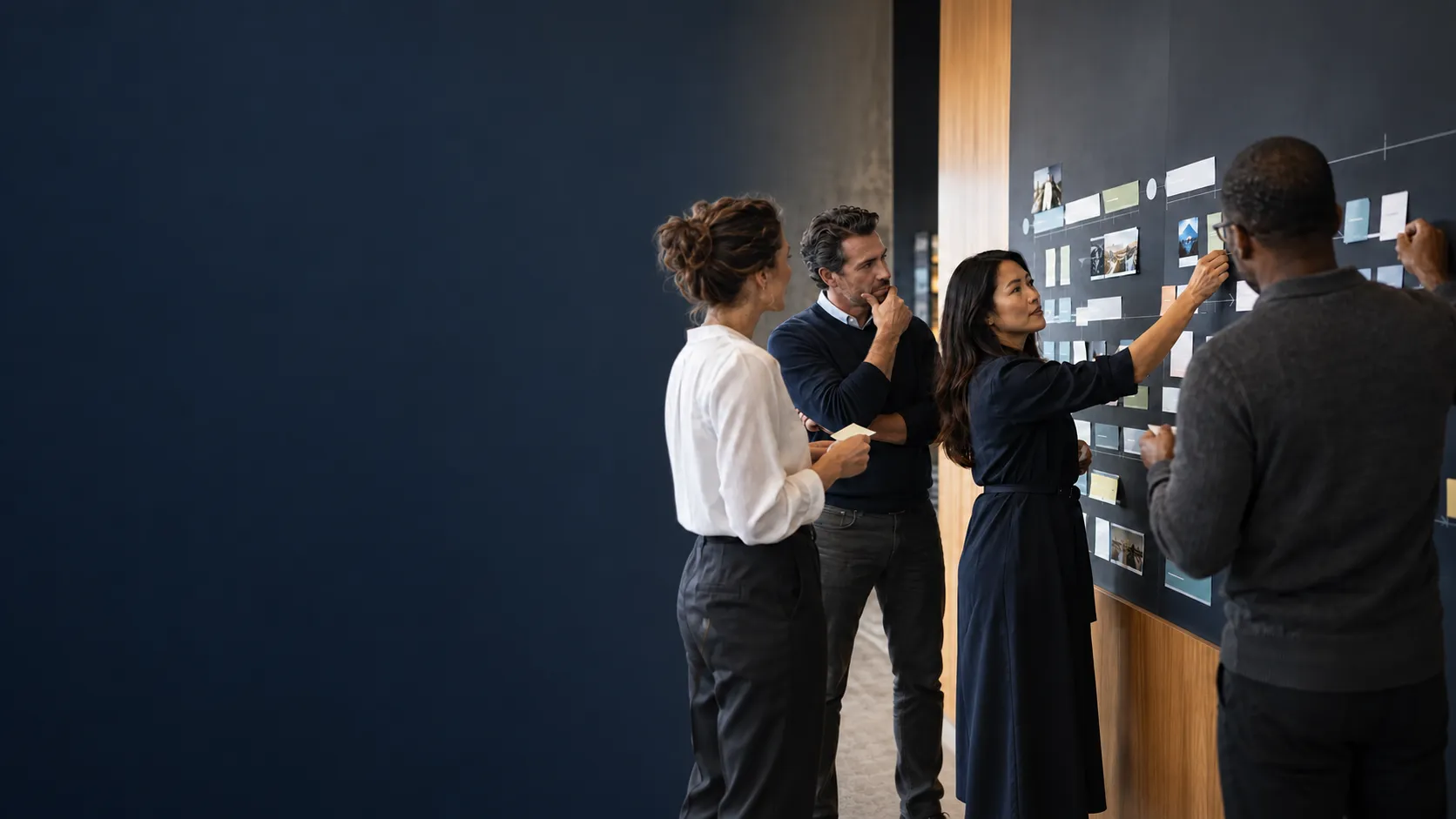 Four colleagues mapping roles and workflows across a planning wall.